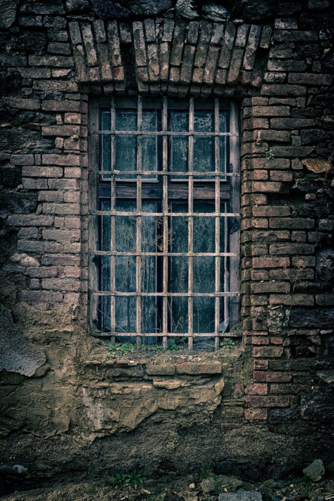 an old barred window in a stone building.