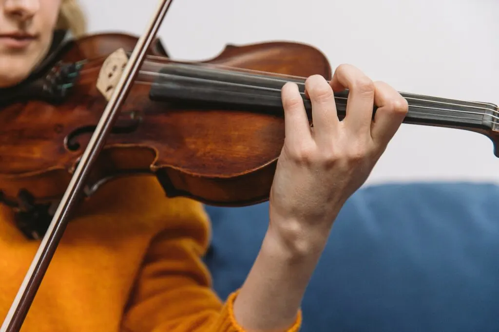 close up of a woman playing a violin.